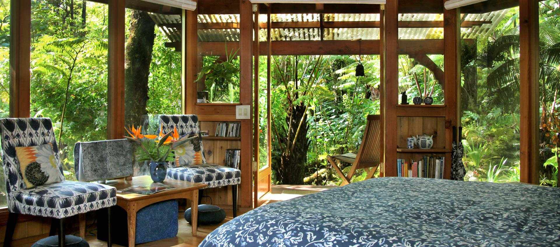 Sanctuary Cottage bed and sitting chairs with rainforest view